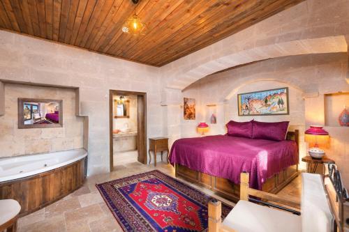 a bedroom with a bed and a bath tub at Megaron Cave Hotel Cappadocia in Ortahisar