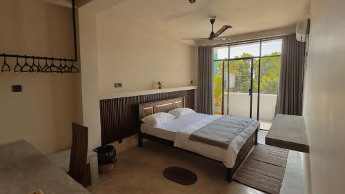 a bedroom with a bed and a large window at Surf's Up LOFT in Weligama