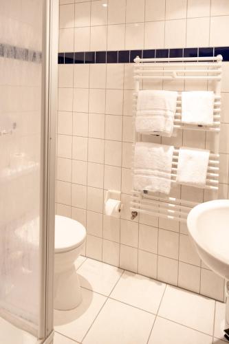 a bathroom with a toilet and a shower with towels at Hotel Eifeltor in Mechernich