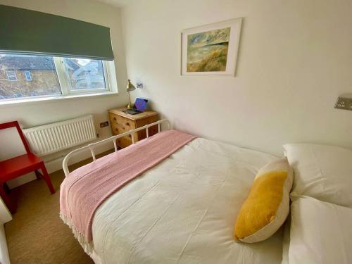 a small bedroom with a bed and a window at Modern 2-Bed Apartment with Off-Street Parking in Chiswick in London