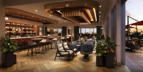 a restaurant with tables and chairs and a bar at InterContinental Indianapolis by IHG in Indianapolis
