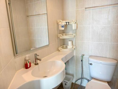a bathroom with a sink and a toilet and a mirror at Studio 5mins to Terminal 21 Lumpini Ville Naklua in North Pattaya