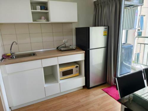 a small kitchen with a refrigerator and a microwave at Studio 5mins to Terminal 21 Lumpini Ville Naklua in North Pattaya