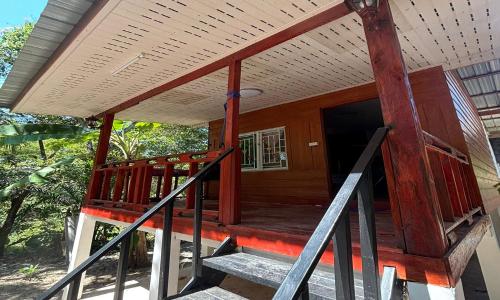 a house with a wooden porch with a door at Duangkeaw Simple House in Phra Ae beach