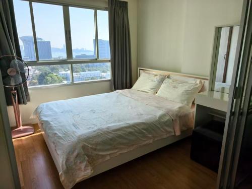 a bedroom with a bed with a large window at Studio 5mins to Terminal 21 Lumpini Ville Naklua in North Pattaya