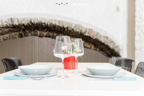 a table with two wine glasses and plates on it at La Grotta in Vernazza