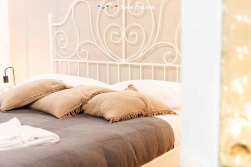 a bed with a white headboard and pillows on it at La Grotta in Vernazza
