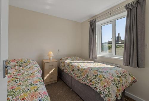 a bedroom with two beds and a window at Landscove Chalet 23 in Brixham