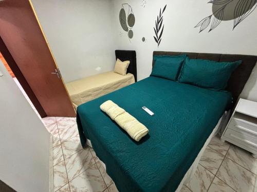 a bedroom with a bed with a green comforter at Casa Vivah in Lençóis