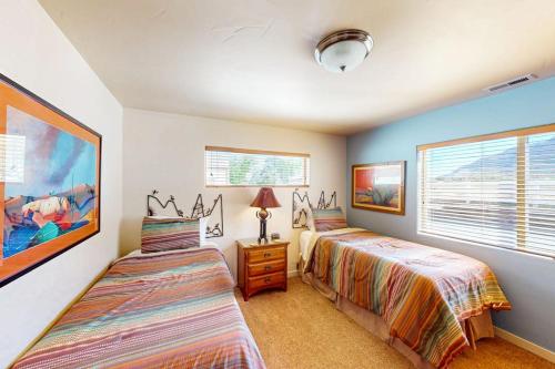 two beds in a room with two windows at Rim Village O3 in Moab
