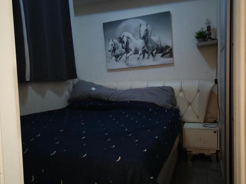 a bedroom with a bed and a picture of horses at Pearl island suite in Ashkelon