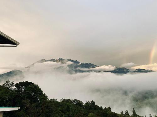 a view of a mountain with clouds and a rainbow at Sanhill & Oasis in Ranau