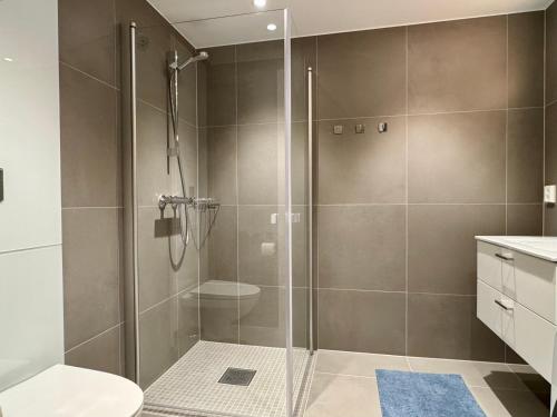 a shower with a glass door in a bathroom at Apartment by Kokstad tram in Bergen
