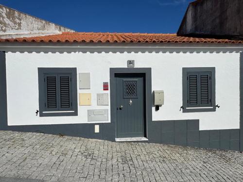 a white building with a door and two windows at Á-do-Couve in Alvito