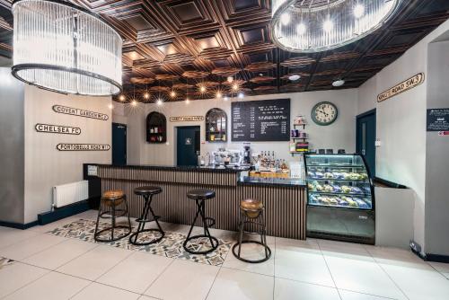 a restaurant with two stools and a counter with a bakery at Rest Up London in London