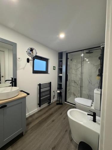 a bathroom with two sinks and a toilet and a shower at Á-do-Couve in Alvito