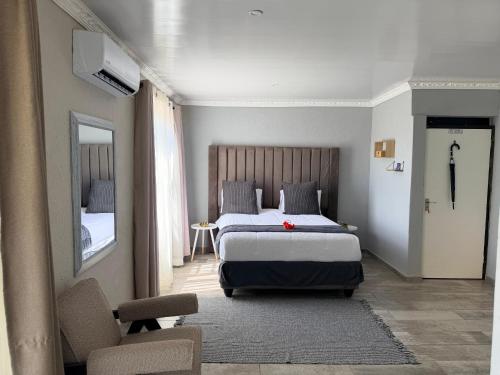 a bedroom with a bed and a chair and a mirror at Yandheya Guest House in Calcutta