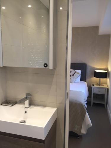 baño con lavabo y cama en Modern 2 Bedroom Flat with private outdoor terrace, en Londres