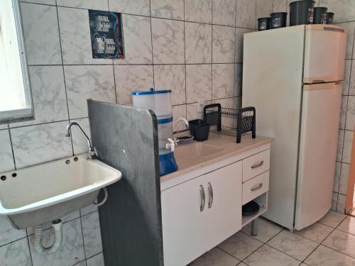 a kitchen with a sink and a refrigerator at Apto inteiro 2 quartos Elvamar in Governador Valadares