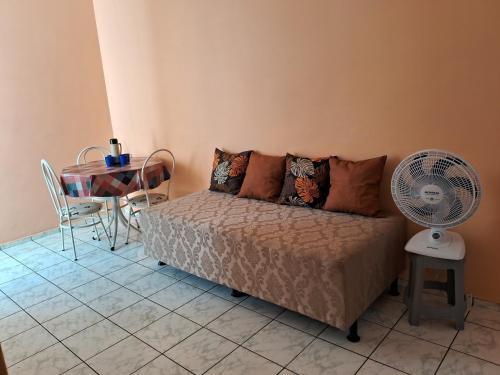 a bedroom with a bed and a table with a fan at Apto inteiro 2 quartos Elvamar in Governador Valadares