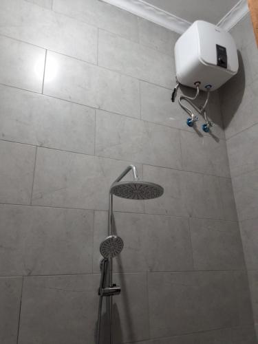 a shower with a shower head in a bathroom at Yigs Motel in Iringa