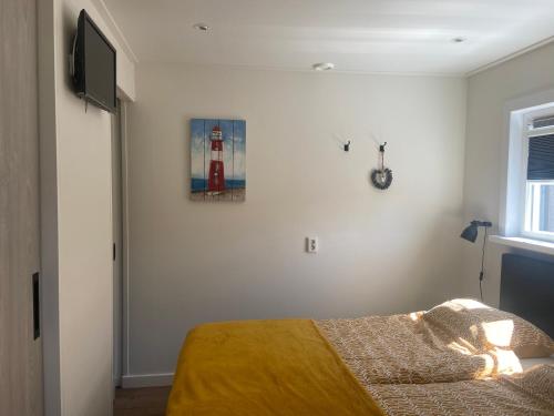 a bedroom with a bed and a picture of a lighthouse at Zon en Zee 2 personen in Westkapelle