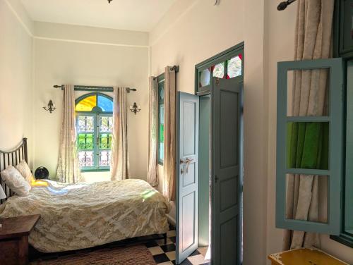 a bedroom with a bed and a window at Aghata Palms Riad in Essaouira