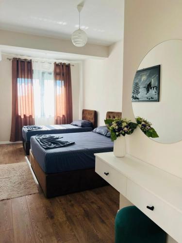 a bedroom with two beds and a mirror at Villa Sarvi in Durrës