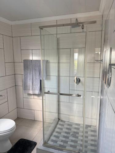 a shower with a glass door in a bathroom at Yandheya Guest House in Calcutta