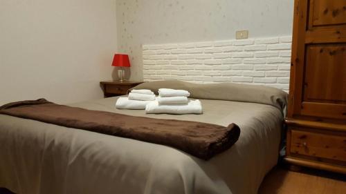 a bedroom with a bed with towels on it at Hotel Calaluna in Biella