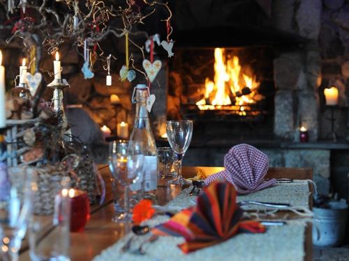 a dinner table with a fireplace in the background at Lower Barns Boutique B&B in St Austell