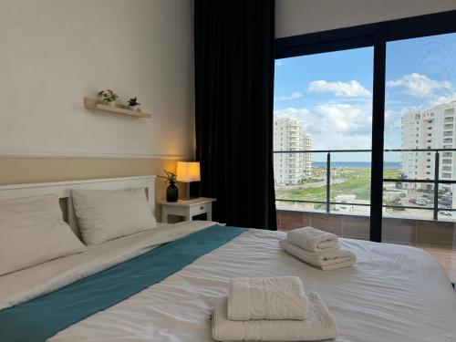 a bedroom with a bed with two towels on it at Nothern Cyprus Caesar Resort & Spa Collection Pools & Long Beach in Aglantzia