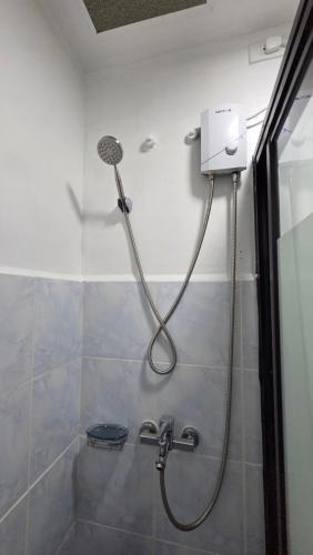 a shower with a shower head in a bathroom at Kim's Cozy Place - Parthenon Residences in Cebu City