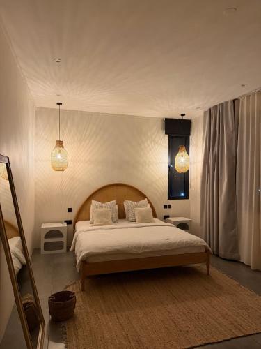 a bedroom with a large bed and two pendant lights at Anba Solēy in Surinam