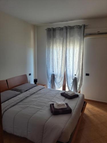 a bedroom with a large bed with white curtains at Campania Home in Terni