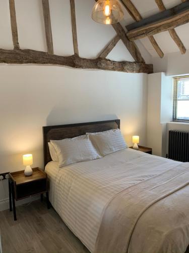 a bedroom with a large bed with two lamps on tables at 3 or 4 Bed 2 Bath Cosy Rural Barn Conversion-Parking in Beoley