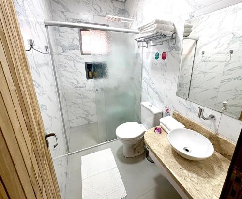 a bathroom with a shower and a toilet and a sink at Pousada Vento Sul in Chapada dos Guimarães