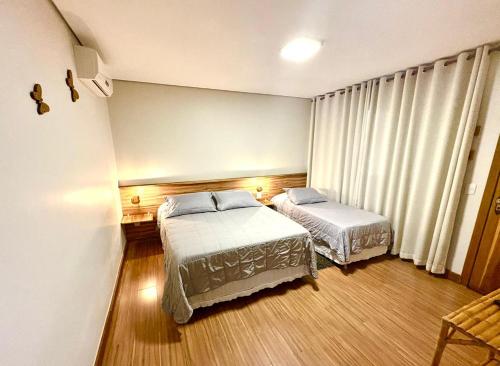 a bedroom with two beds and a window at Pousada Vento Sul in Chapada dos Guimarães