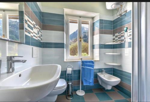 a bathroom with a sink and a toilet and a window at Casa Gaia a soli 20 mt dal mare in Pomonte