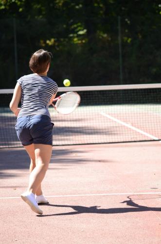 a woman hitting a tennis ball with a racket at Village Vacances de Chantonnay in Chantonnay