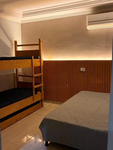 a bedroom with two bunk beds and a ladder at Onde o verão nunca termina! in Peruíbe