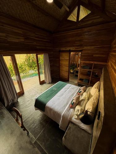 a bedroom with a large bed in a room with windows at Villa Naka - Gili Trawangan - Traditional Villa & Private pool in Gili Trawangan