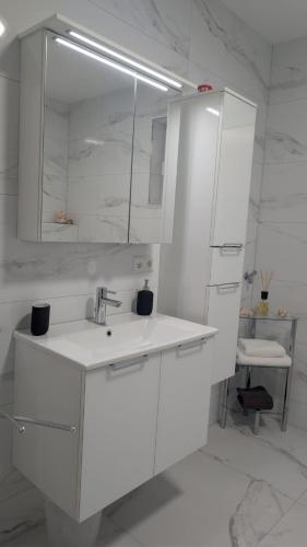 a white bathroom with a sink and a mirror at Gemütliche Wohnung mit Terrasse nahe Würth in Künzelsau
