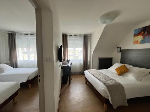 a hotel room with two beds and a television at The Originals Boutique, Hôtel de La Baie de Morlaix in Carantec