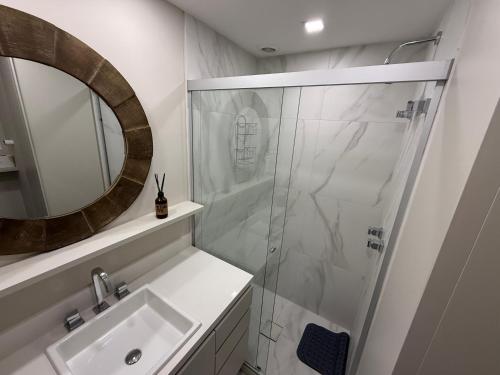 a bathroom with a shower and a sink and a mirror at Studio JP Redenção in Porto Alegre