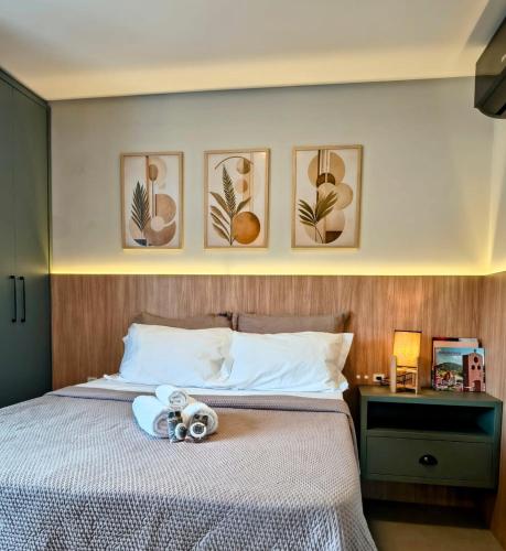 a bedroom with a bed with four pictures on the wall at 1106 - Vila Germânica in Blumenau
