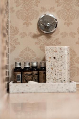 a shelf with five jars of spices on a wall at Pensiunea Eden in Târgu Neamț