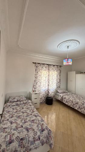 a bedroom with two beds and a window at Maison campagne piscine ksar in Ksar es Sghir