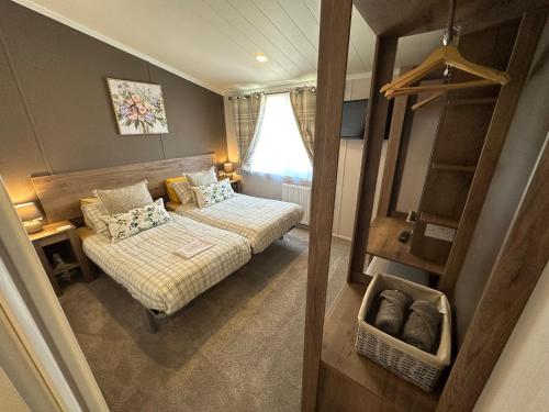a small bedroom with a bed and a mirror at Luxury Lakeside Lodge L2 with Hot tub situated at Tattershall Lakes Country Park in Tattershall