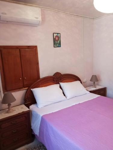 ein Schlafzimmer mit einem lila Bett und zwei Kissen in der Unterkunft Georgia's in Ayía Kiriakí